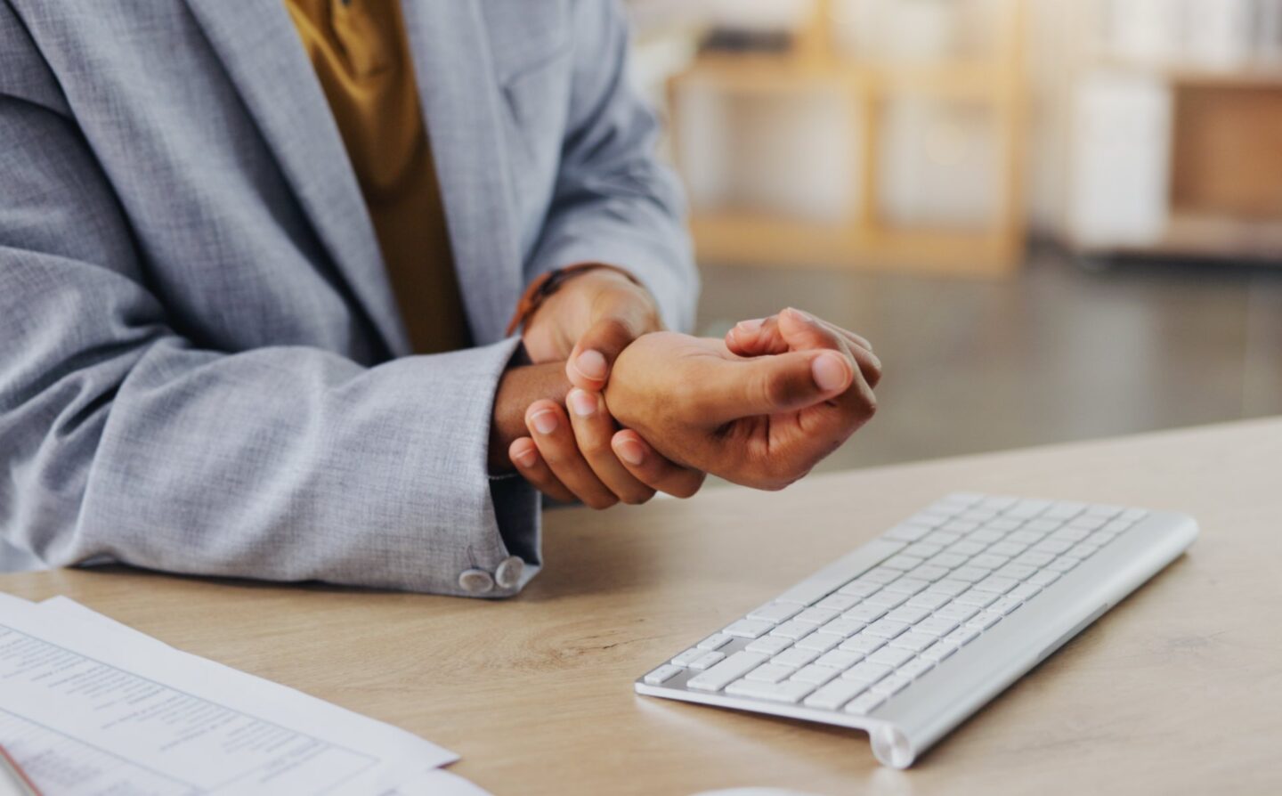 Person holding their wrist in front of a keyboard