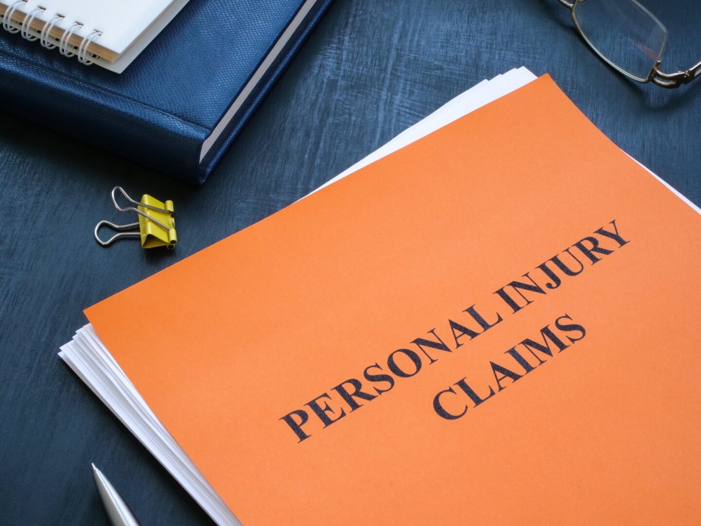 Stack of papers with an orange one at the top that says personal injury claims