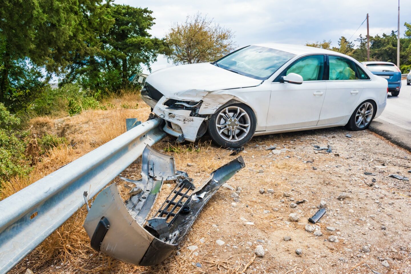 A white car crashed into a guard rail