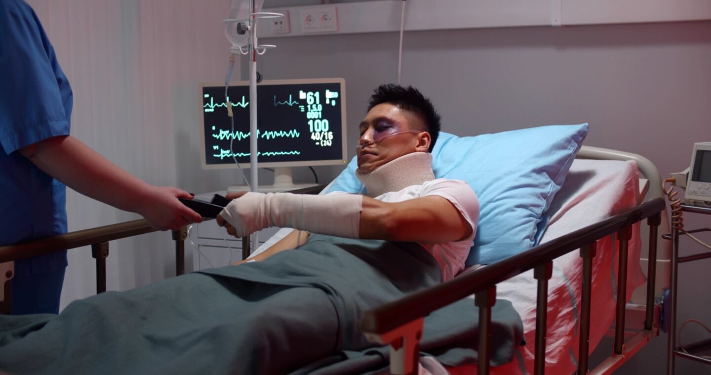 Male patient in hospital bed with a cast on arm